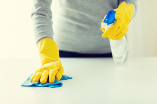 Office cleaning team sanitising desks and shared surfaces